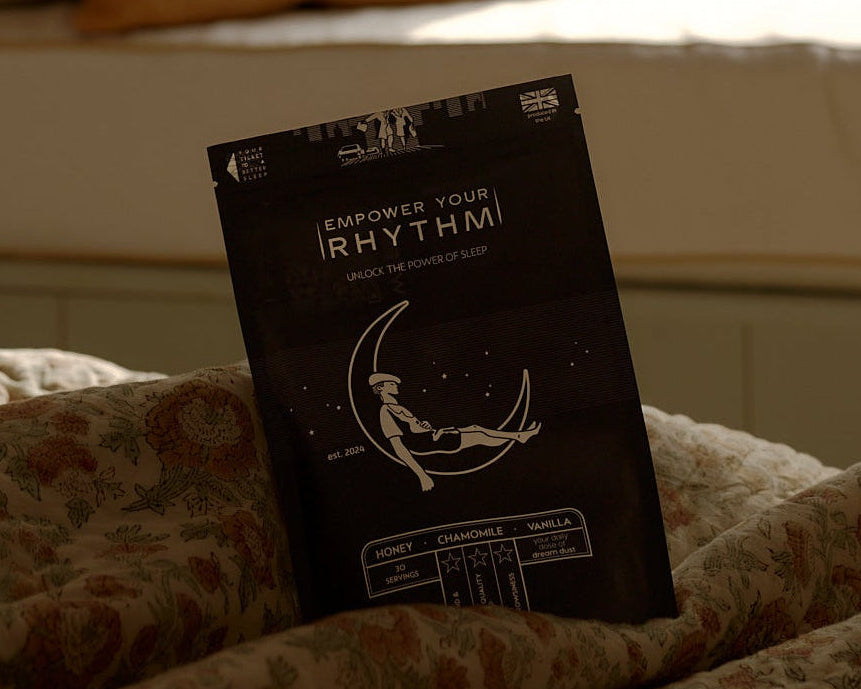 Book titled 'Rhythms' on a bed with pillows and a window in the background